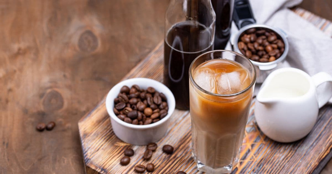 Cold brew coffee with ice, coffee beans, and cream showing how to make cold brew at home